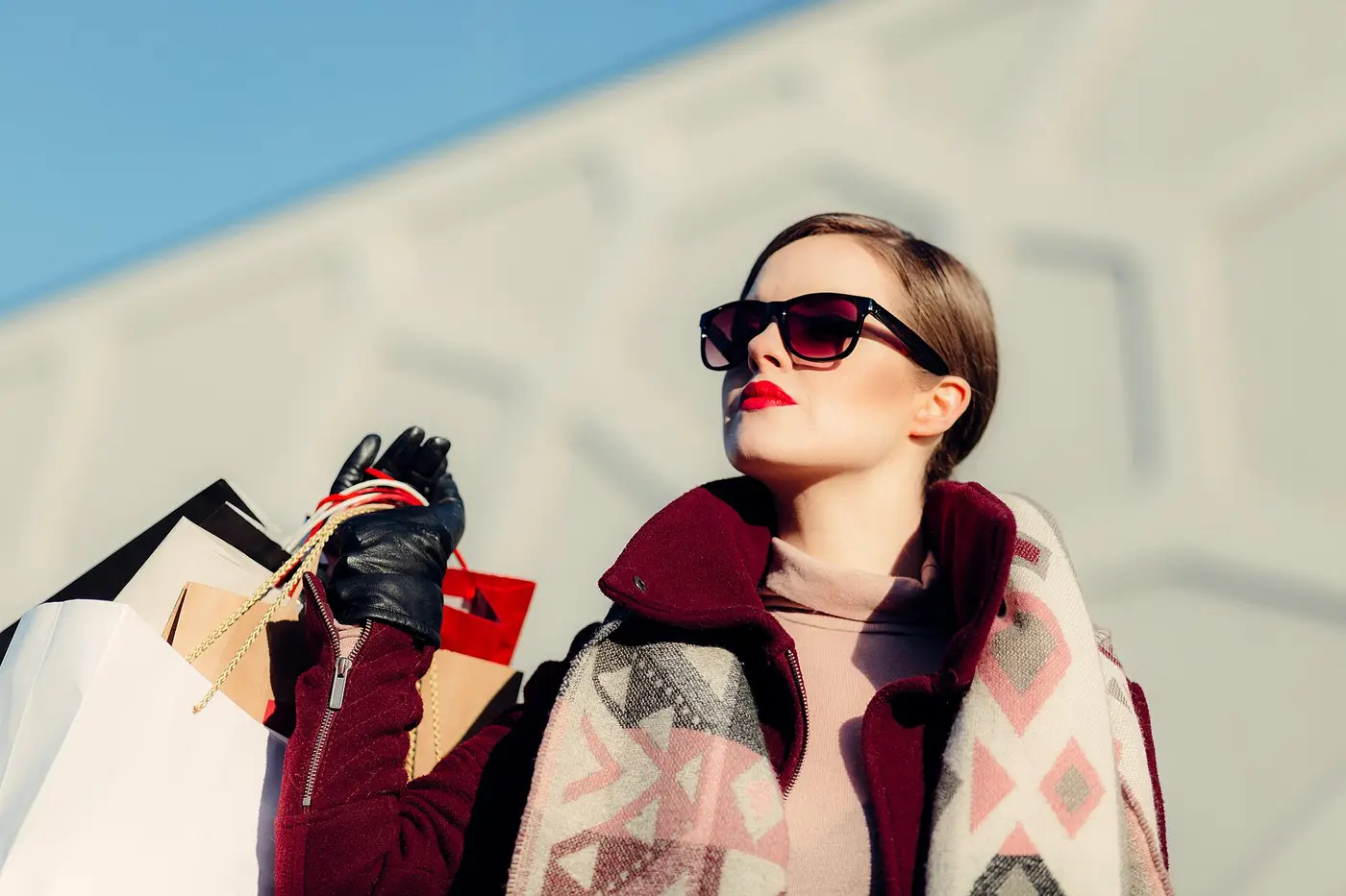 Femme en manteau bordeaux et lunettes noires